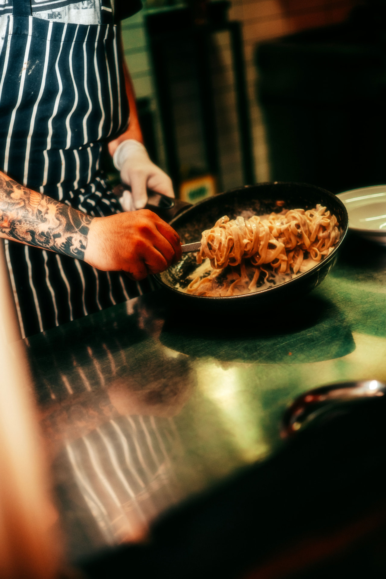 Chef tossing fresh pasta in a pan