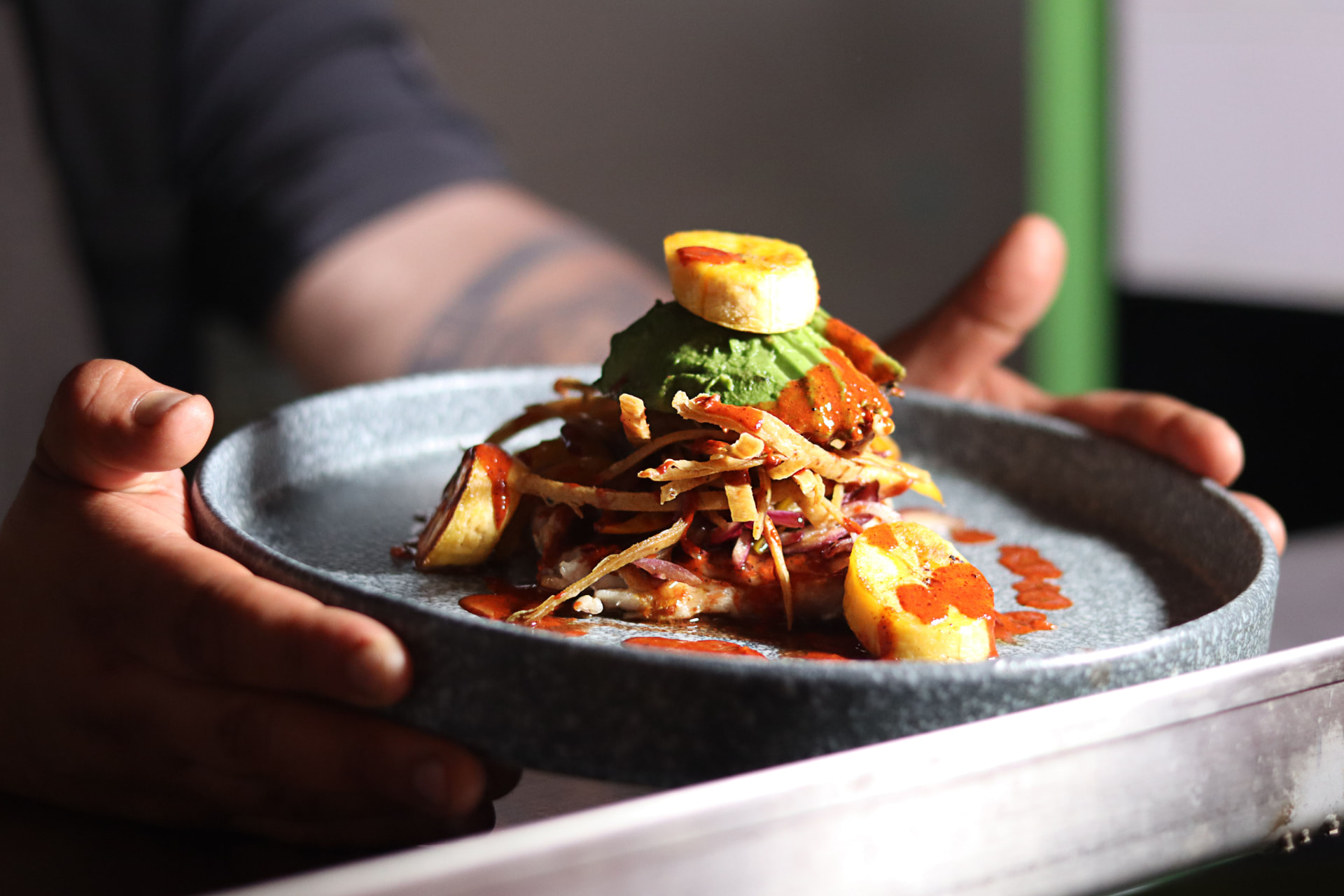 Mexican-style dish held by a server